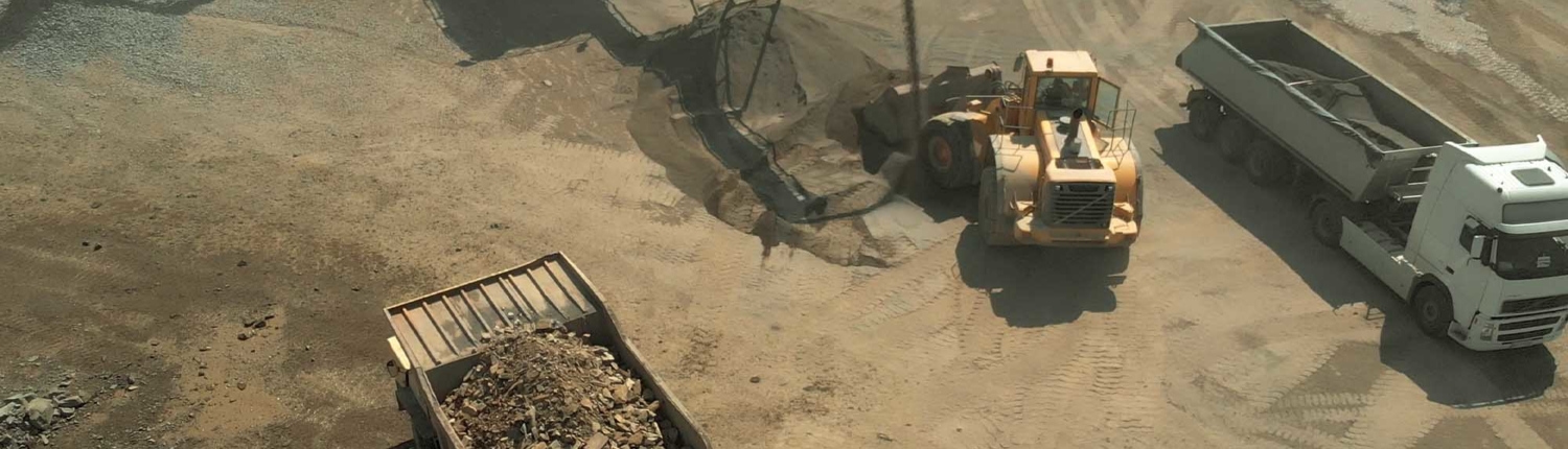 Bulldozer and dump truck loading up sand