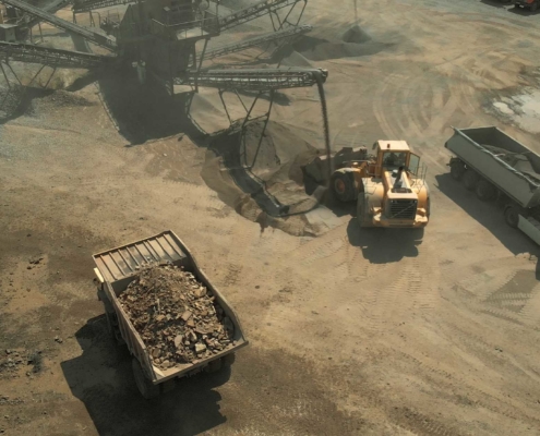 Bulldozer and dump truck loading up sand