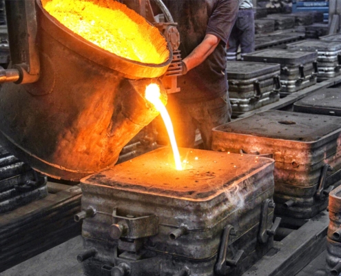 Side view of molten metal being poured into a cast